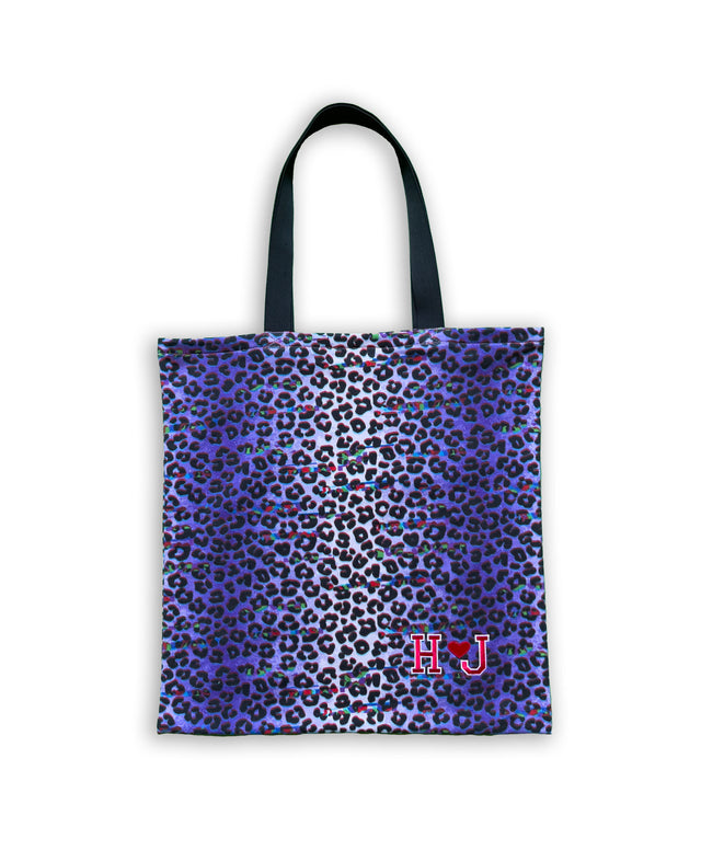 Still life della shopping bag 'Sportea' con stampa leopardata, su sfondo viola. La borsa si distingue per il logo ricamato sul fronte che presenta le lettere 'H' e 'J' accanto a un cuore. La Sportea rappresenta un mix ideale di moda e praticità per lo shopping quotidiano.